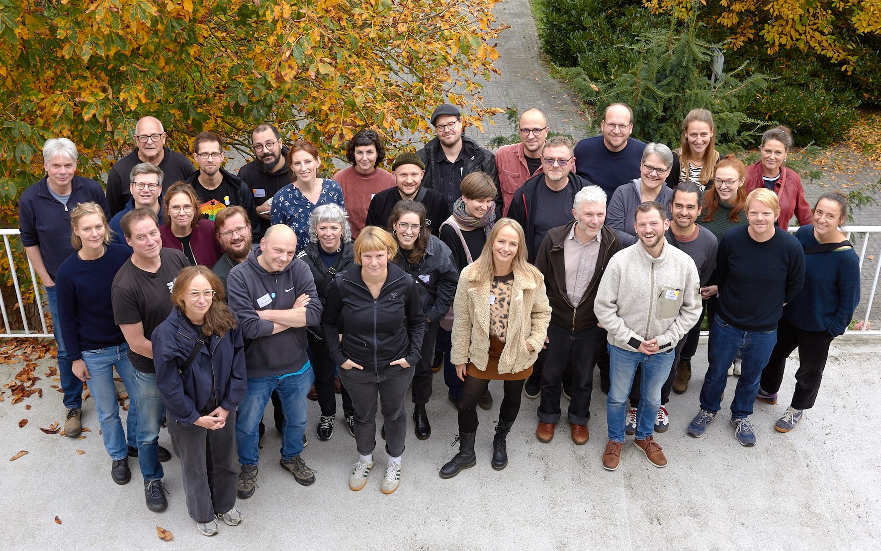Ein Foto von der Vollversammlung des Bundesverbands Mobile Beratung im Oktober 2025: Mehrere Menschen stehen vor Bäumen.