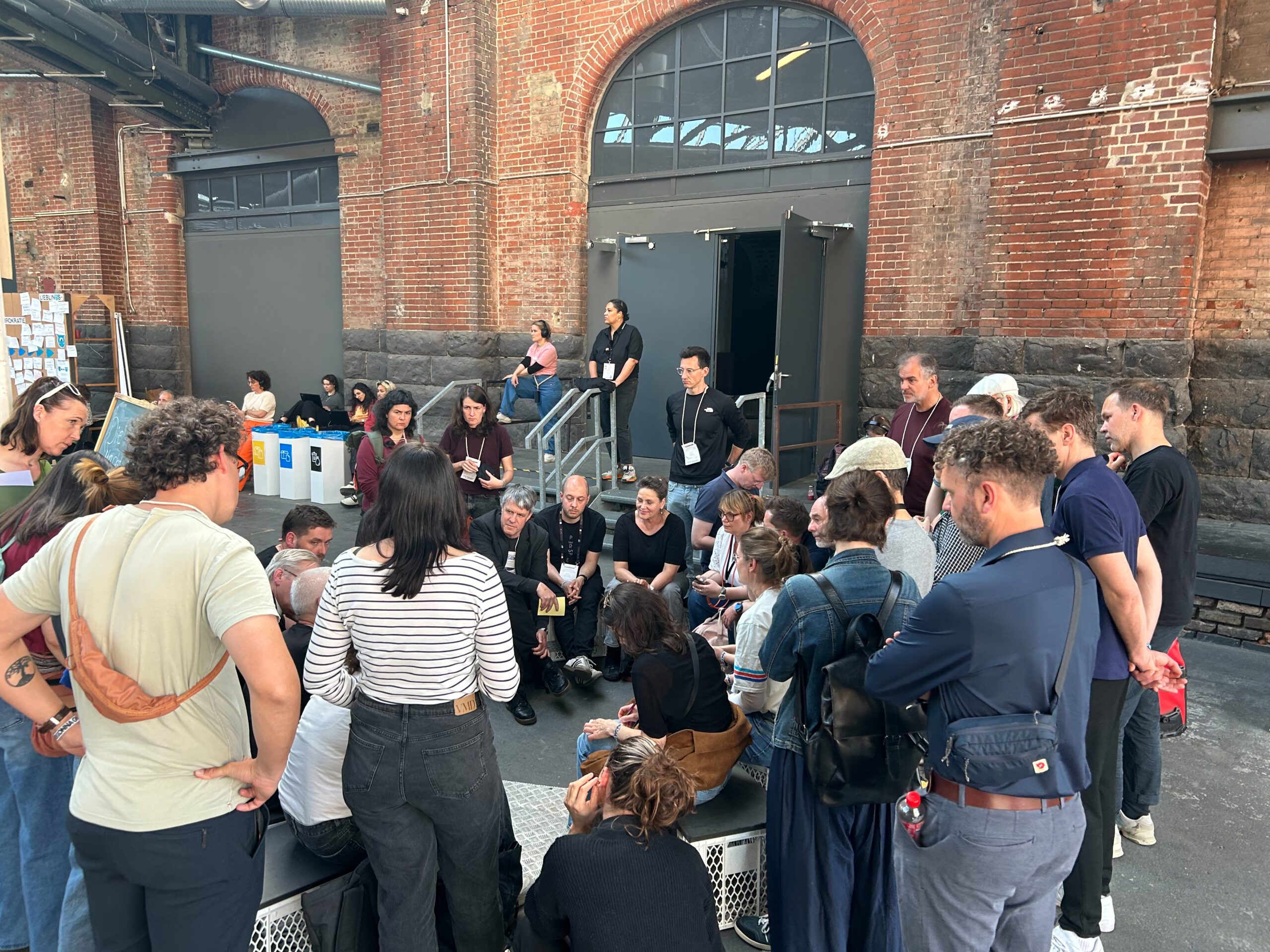 Mehrere Menschen auf der re:publica 2026 stehen im Kreis und hören einer Diskussion zu.